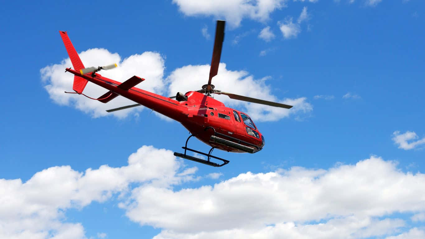 1366x768 Helicopters 桌布 壁紙 — 一架鮮紅色的直升機在點綴著蓬鬆白雲的明亮藍天中翱翔。