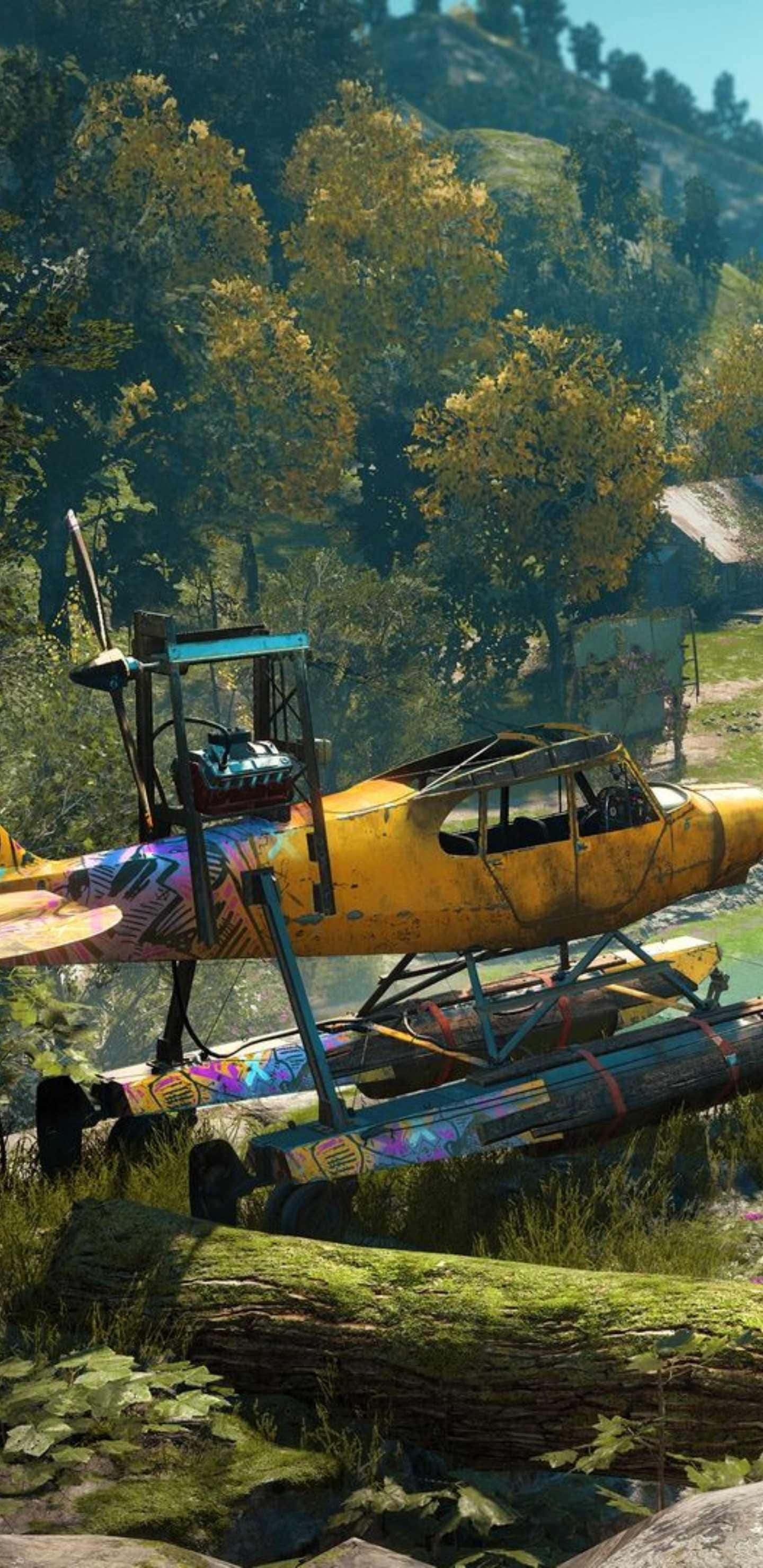 Android Far Cry New Dawn 桌布 壁紙 — 一架鮮黃色水上飛機帶有色彩繽紛的塗鴉，停放在陽光普照的森林空地中的長滿青苔的木頭上。
