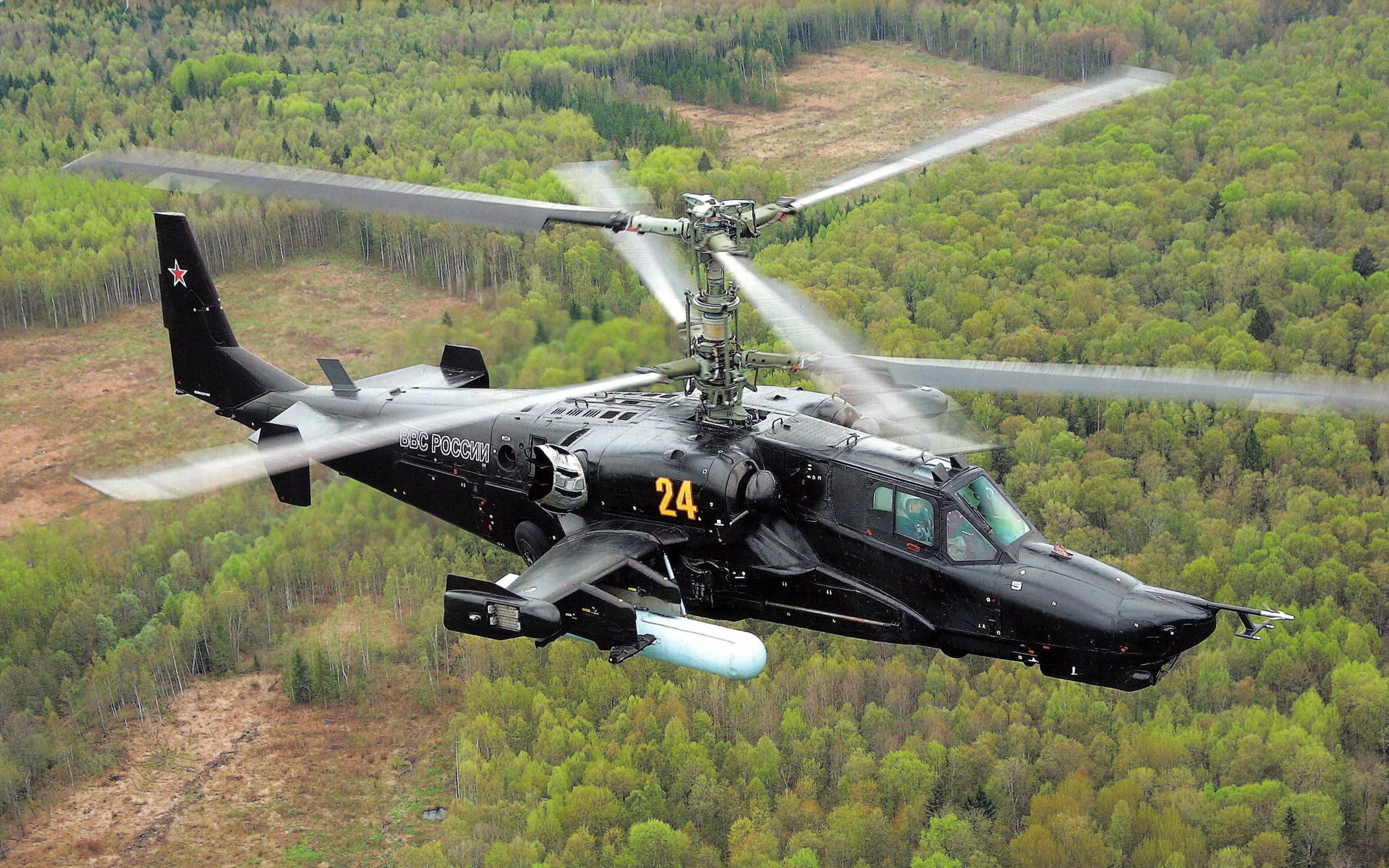 Helicopter 桌布 壁紙 — 一架黑色俄羅斯軍用直升機低飛過茂密綠色森林，旋翼轉動。
