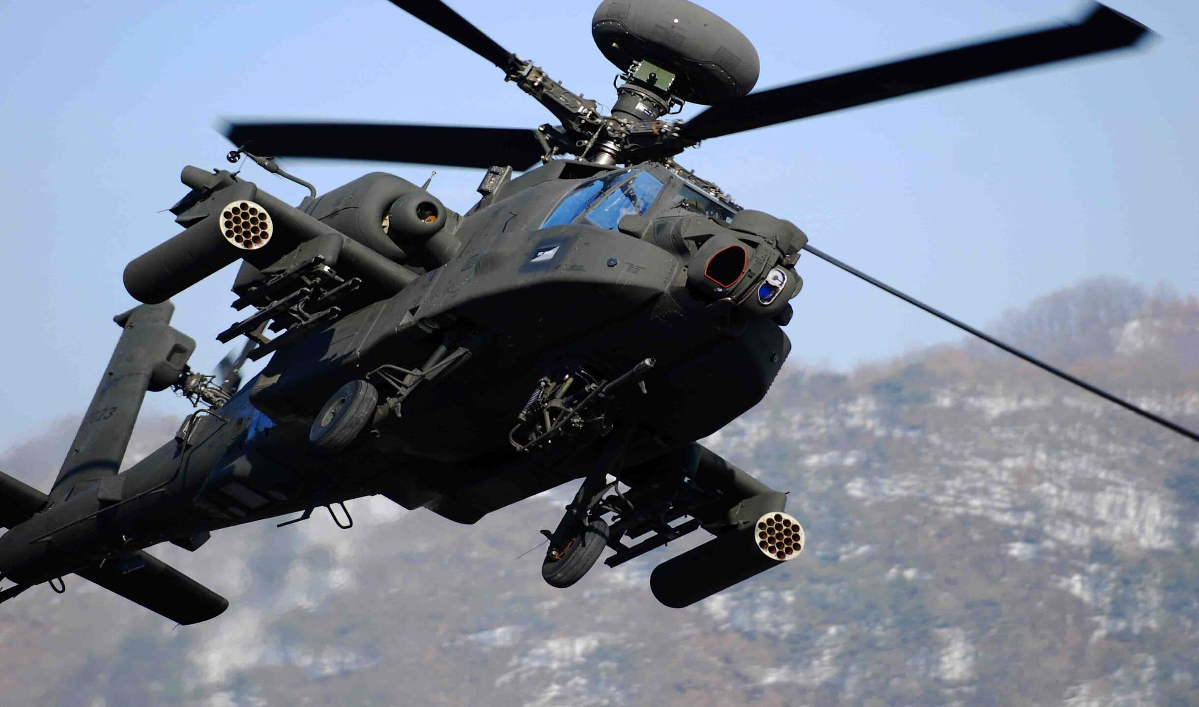 2440x1440 Helicopters 桌布 壁紙 — 一架黑色軍用攻擊直升機在晴朗藍天下低飛越過積雪的山脈。