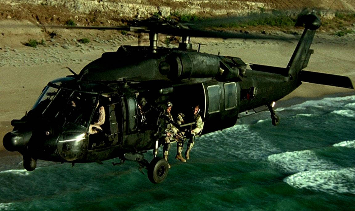 soldier 桌布 壁紙 — 一架黑色軍用直升機低空盤旋在碧綠的海浪之上，士兵們正沿繩索降落到沙灘附近的海水中。