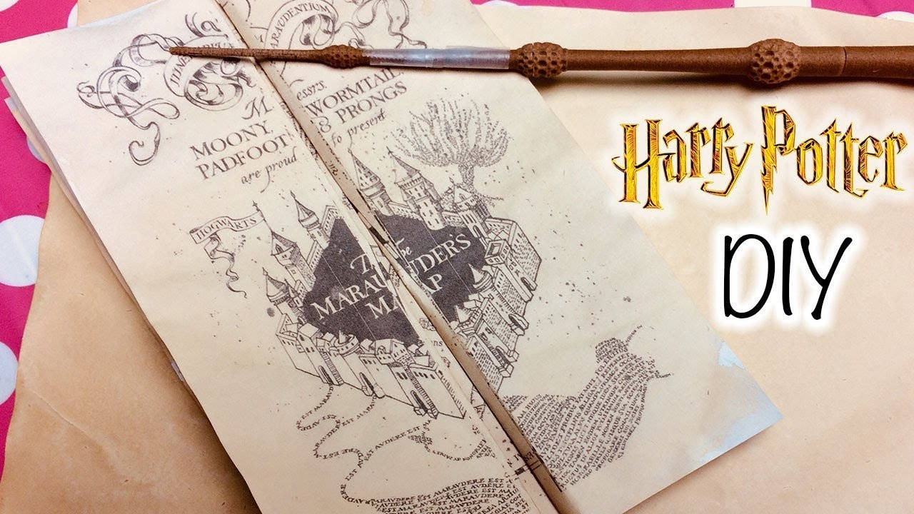 Map 桌布 壁紙 — 一根手工製作的哈利波特魔杖放在詳細的劫盜地圖上，地圖上繪有霍格華茲，背景為粉紅色圓點。