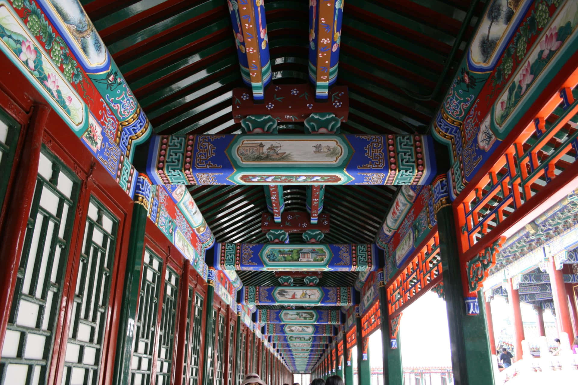彩色動圖 桌布 壁紙 — 一條充滿活力的傳統中式走廊，帶有精緻彩繪的橫樑和紅色漆柱，延伸至遠方。