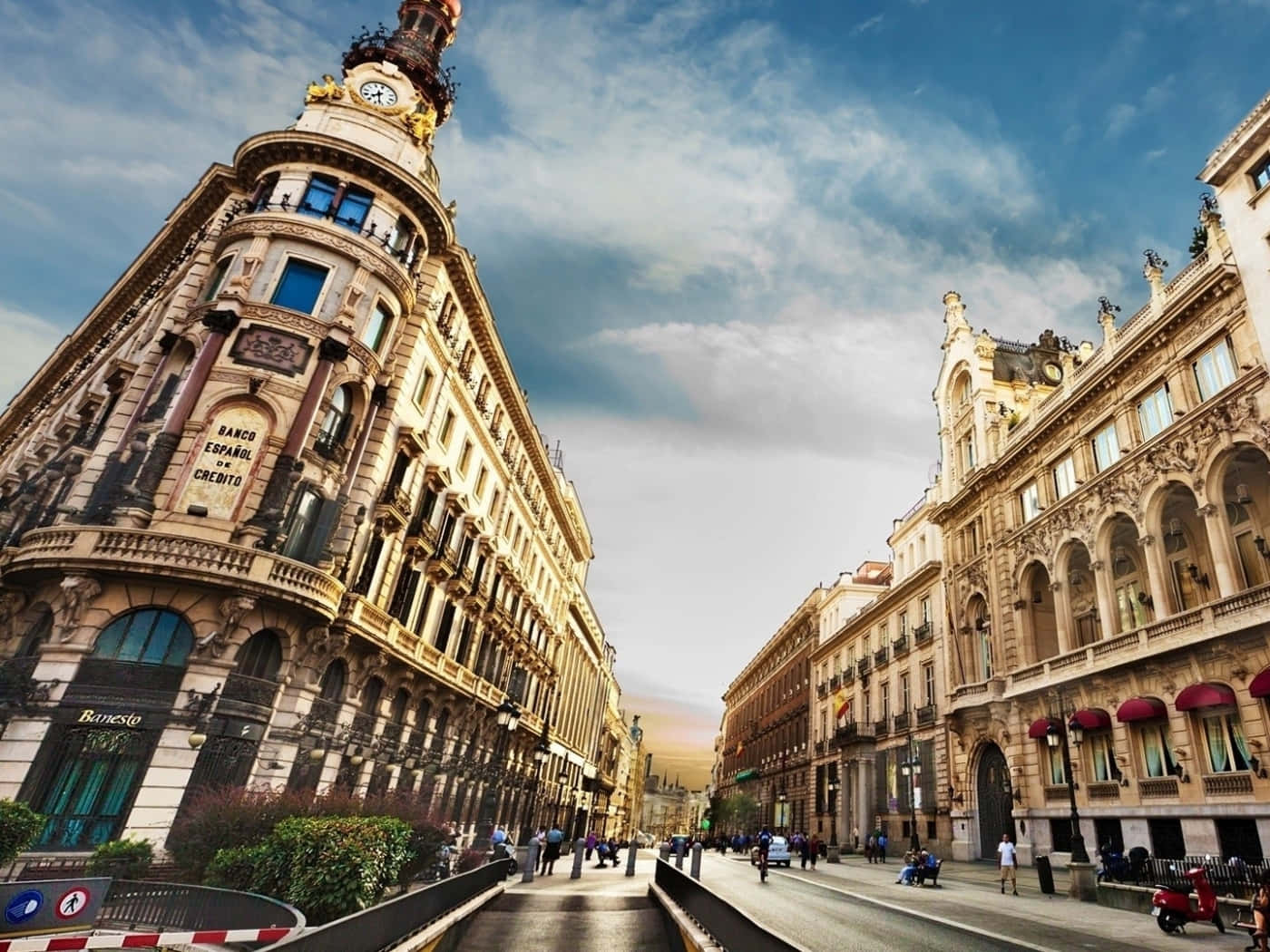 Barcelona 桌布 壁紙 — 一條充滿活力的城市街道，兩旁是華麗的歷史建築，上方是明亮的藍天和零星的白雲。