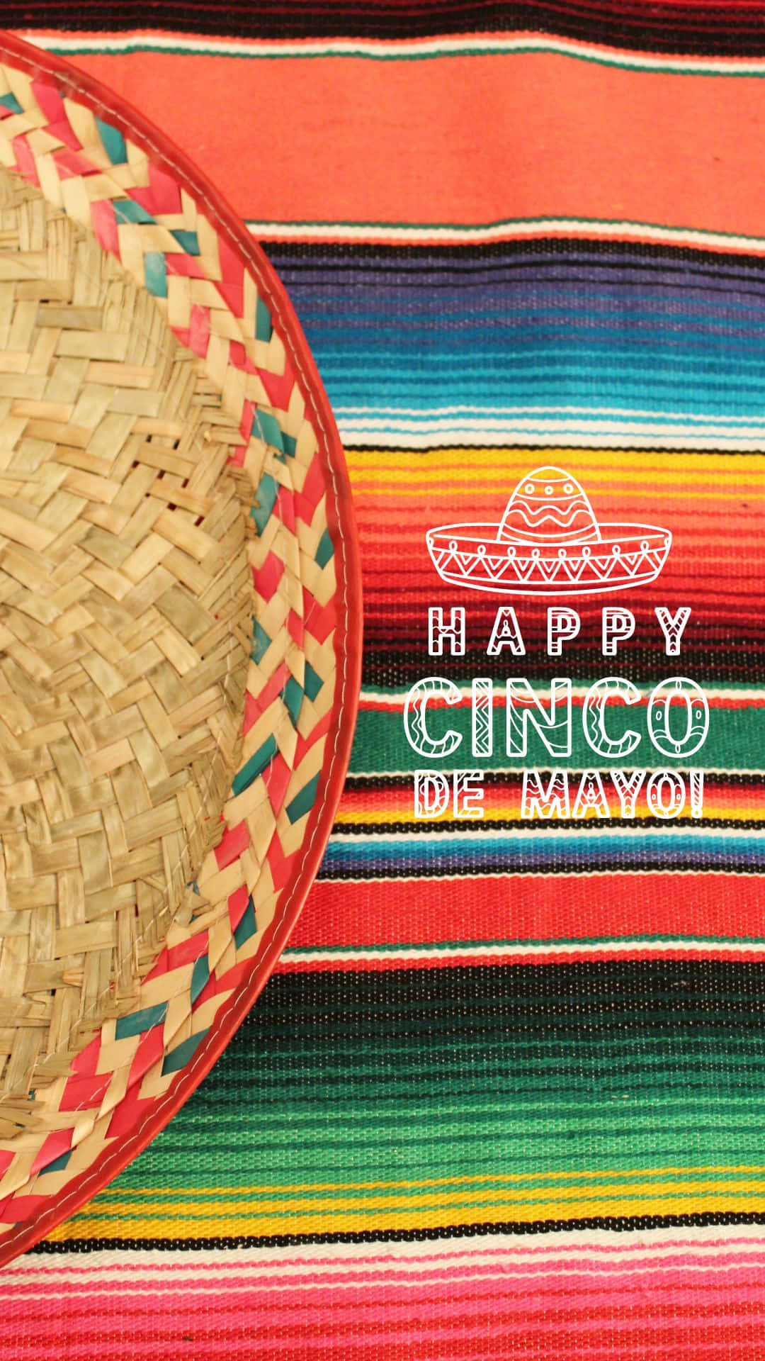 Cinco De Mayo 桌布 壁紙 — 一條充滿活力的塞拉普毯子，帶有鮮明的條紋和一個編織的墨西哥闊邊帽，上面寫著「Happy Cinco de Mayo」。