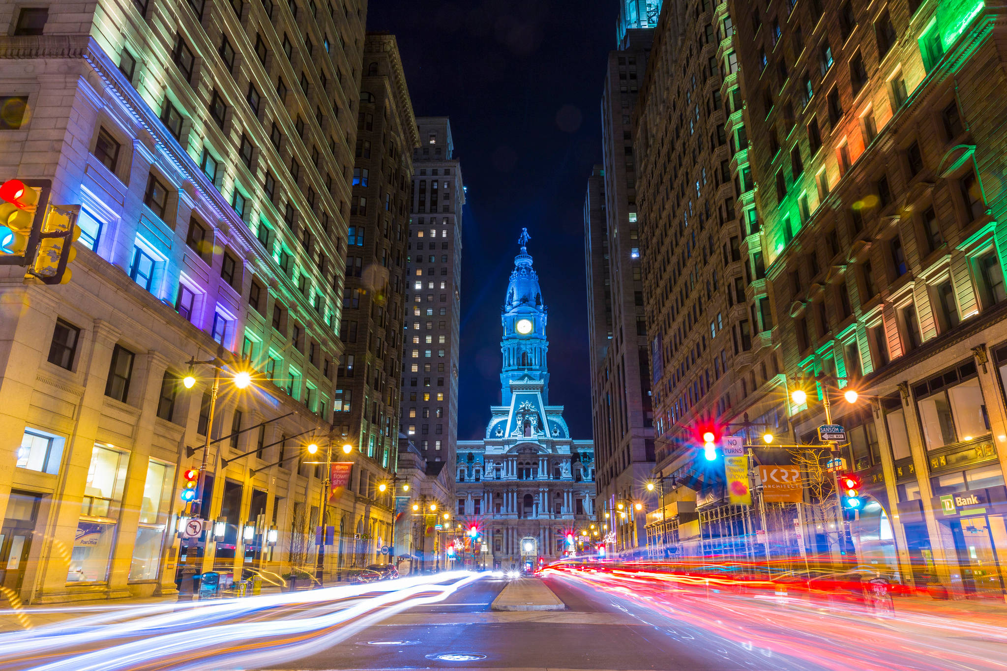 Philadelphia 桌布 壁紙 — 一條充滿活力的夜間城市街道，車流留下光跡，大道盡頭有一座宏偉的燈光鐘樓。