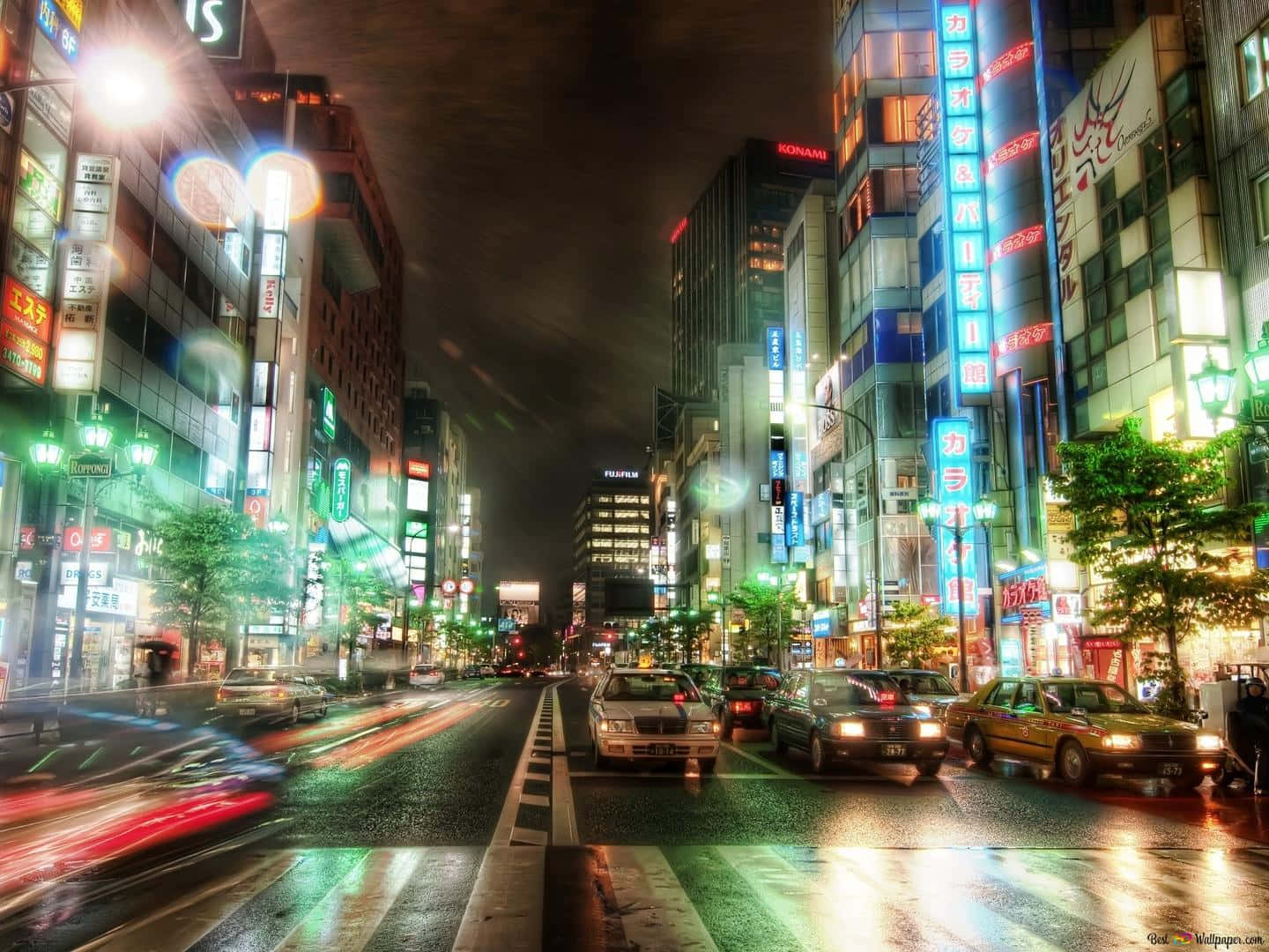 城市 桌布 壁紙 — 一條充滿活力的東京霓虹燈街道夜景，車燈在濕漉漉的路面上留下光跡。