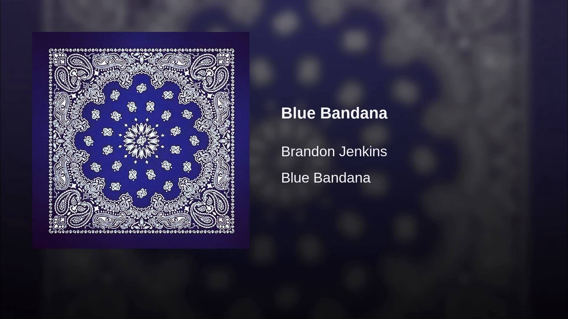 bandana 桌布 壁紙 — 一條充滿活力的藍色頭巾，帶有複雜的白色佩斯利圖案，置於模糊的深色背景中央。