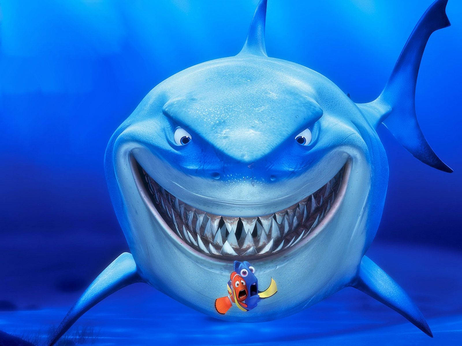 nemo 桌布 壁紙 — 一條卡通鯊魚咧嘴大笑，嘴裡叼著一條小丑魚在水下。