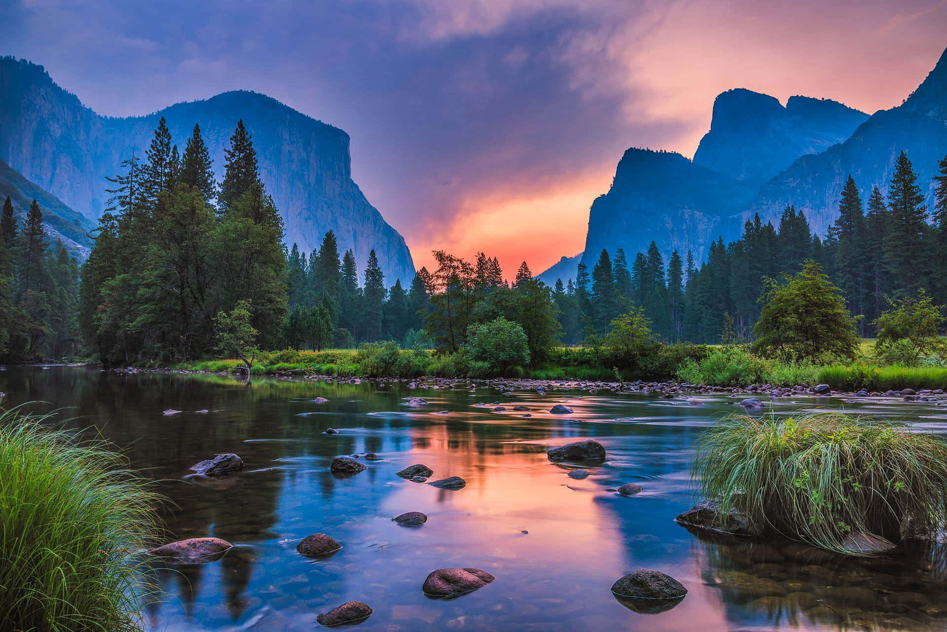river 桌布 壁紙 — 一條寧靜的河流在日落時分流經森林覆蓋的山谷，兩旁是高聳的懸崖和色彩斑斕的天空倒影。