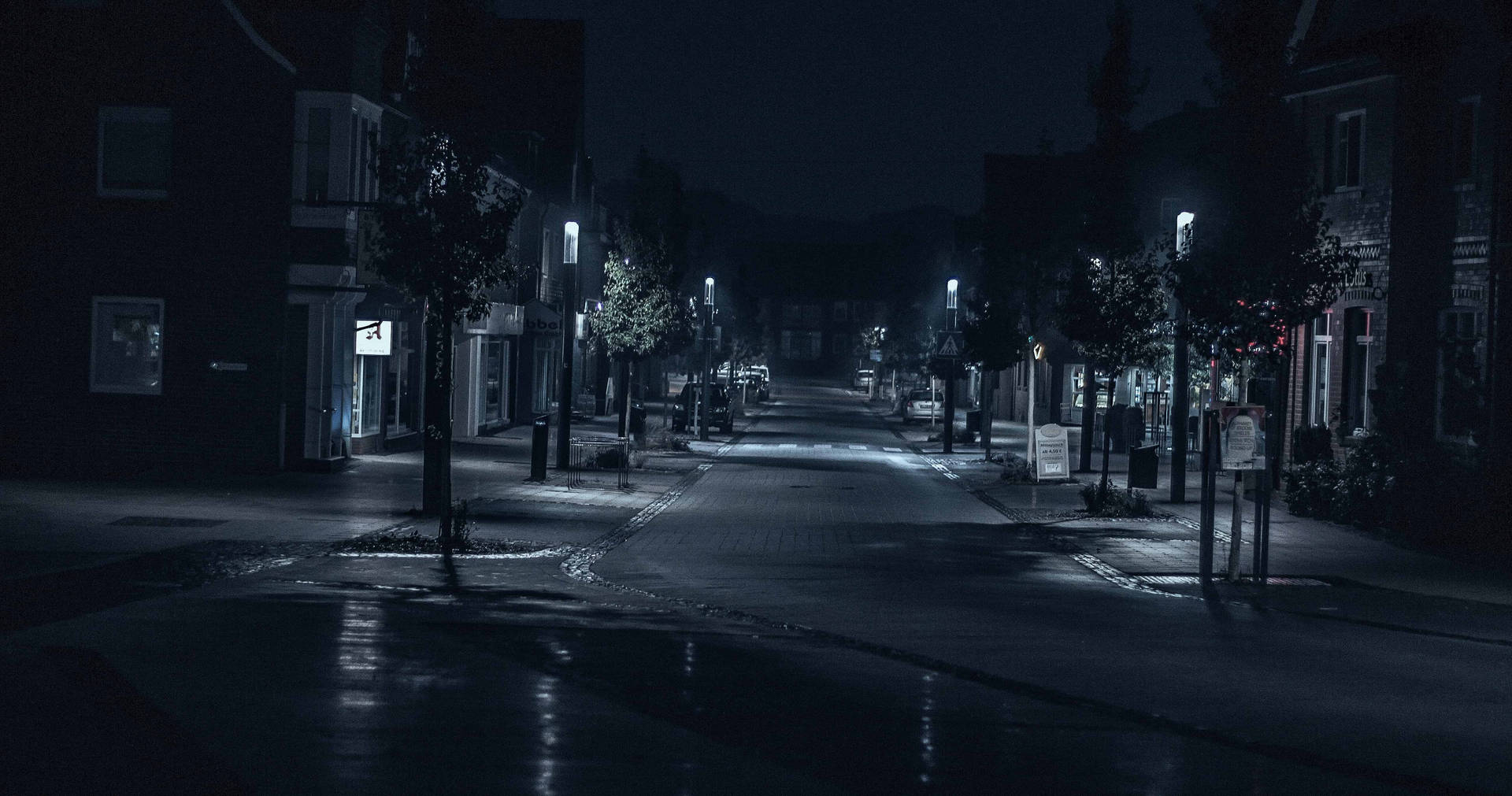 夜晚空無一人的城市街道，濕漉漉的路面反射著路燈。 — 深藍色美學動圖 壁紙