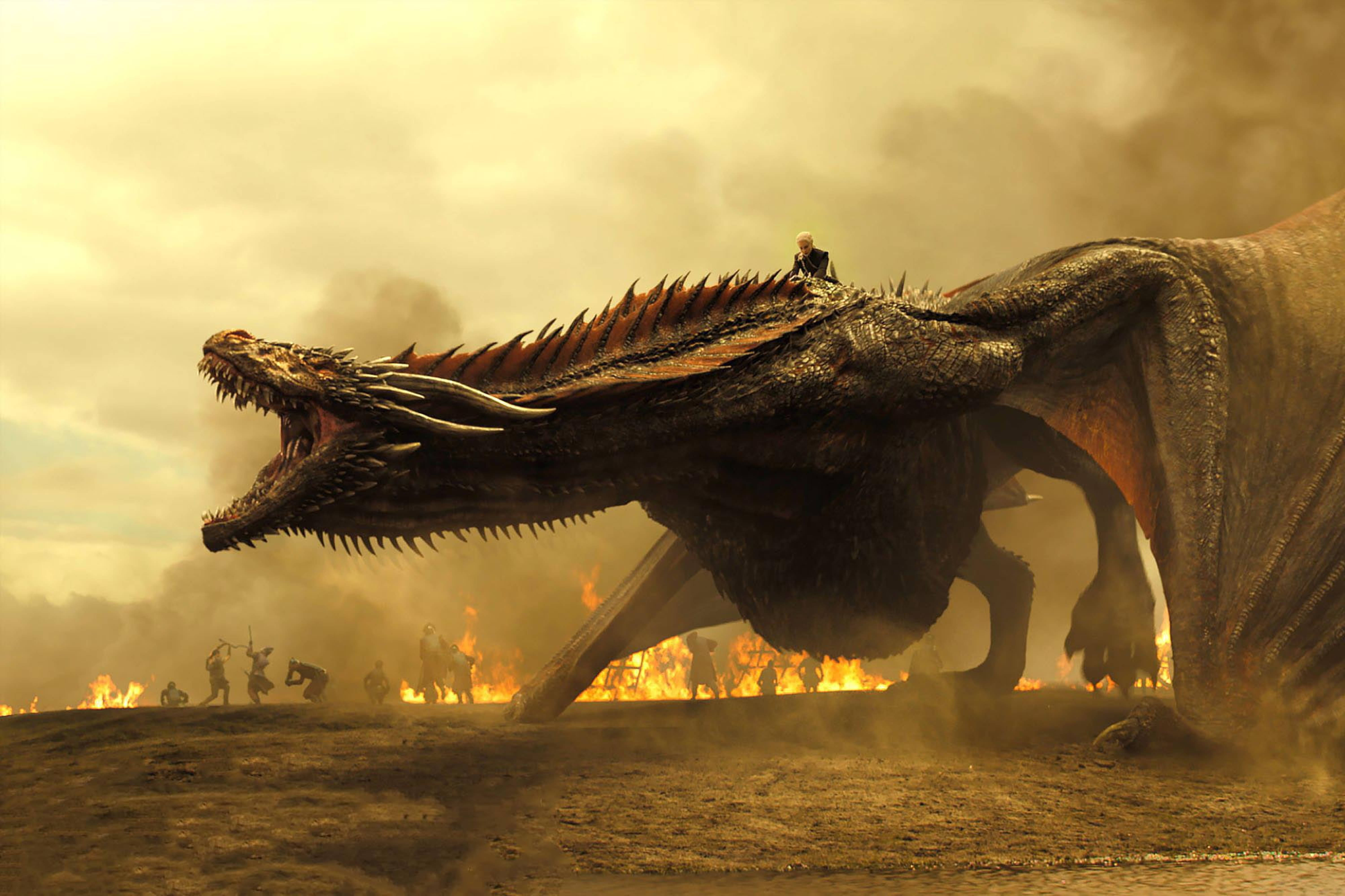 daenerys 桌布 壁紙 — 一條巨大的龍與騎手在煙霧瀰漫的天空下，於被火焰和煙霧籠罩的戰場上咆哮。