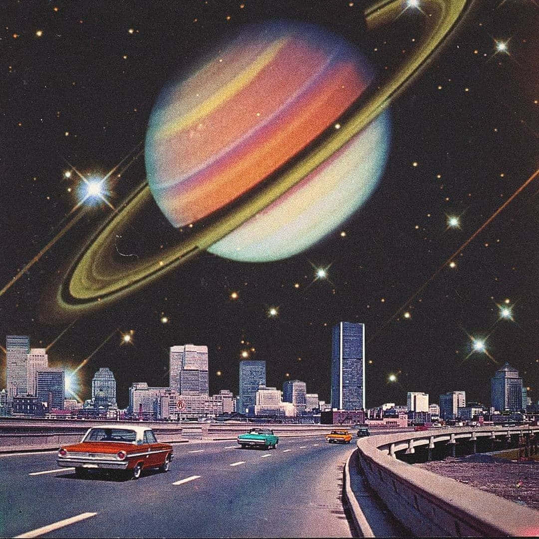 迷幻動圖 桌布 壁紙 — 一條復古高速公路，經典汽車在巨大的土星下行駛，土星籠罩著夜晚未來主義的城市天際線。