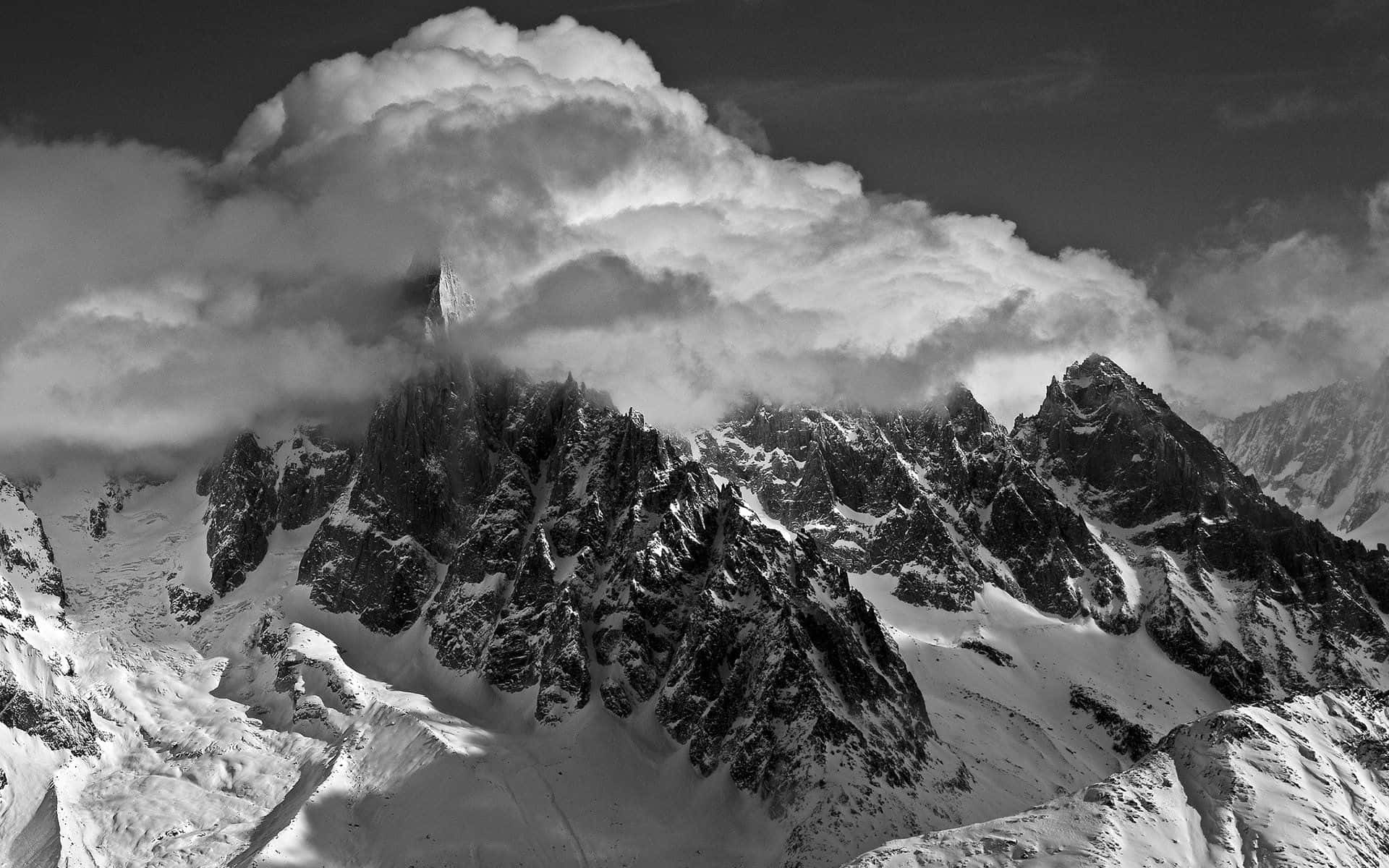 Black And White Landscape 桌布 壁紙 — 一條戲劇性的黑白山脈，積雪的山峰部分被厚雲遮蓋。