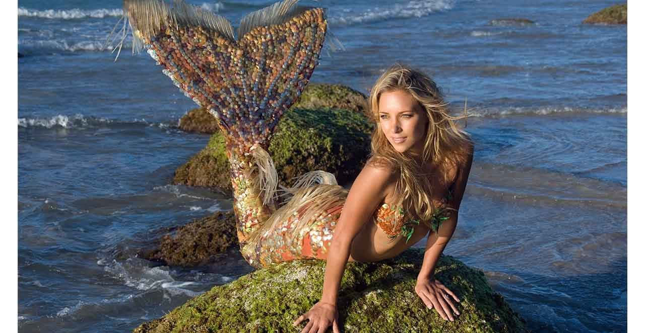 Mermaid Real Life 桌布 壁紙 — 一條擁有珠飾尾巴的美人魚在海邊長滿苔蘚的岩石上休息，海浪在附近拍打。
