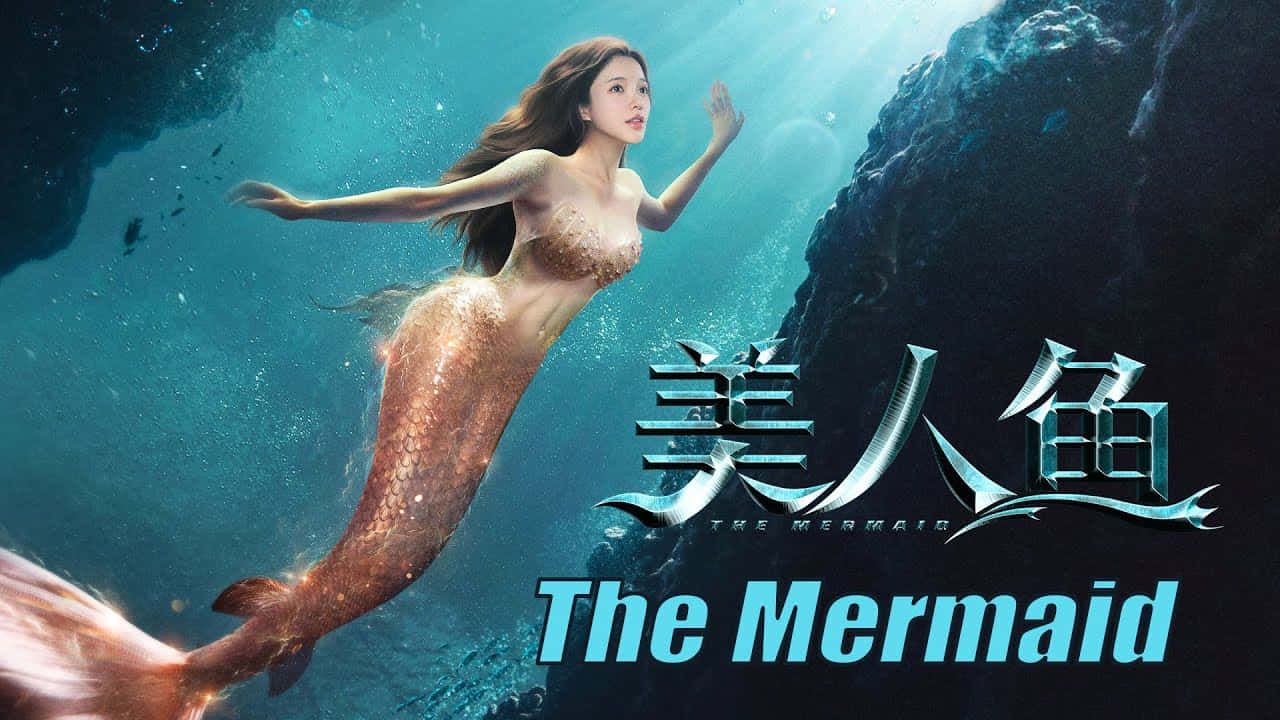 Mermaids 桌布 壁紙 — 一條擁有金色鱗片的優雅美人魚在陽光照耀的藍綠色海水中，在黑暗的海底懸崖旁邊滑行。