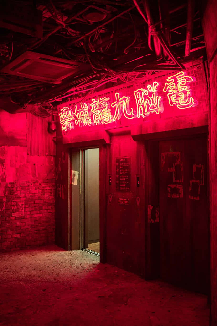 美學 桌布 壁紙 — 一條昏暗的城市小巷，被上方破舊門戶上發光的中文招牌所散發的強烈紅色霓虹燈光所籠罩。