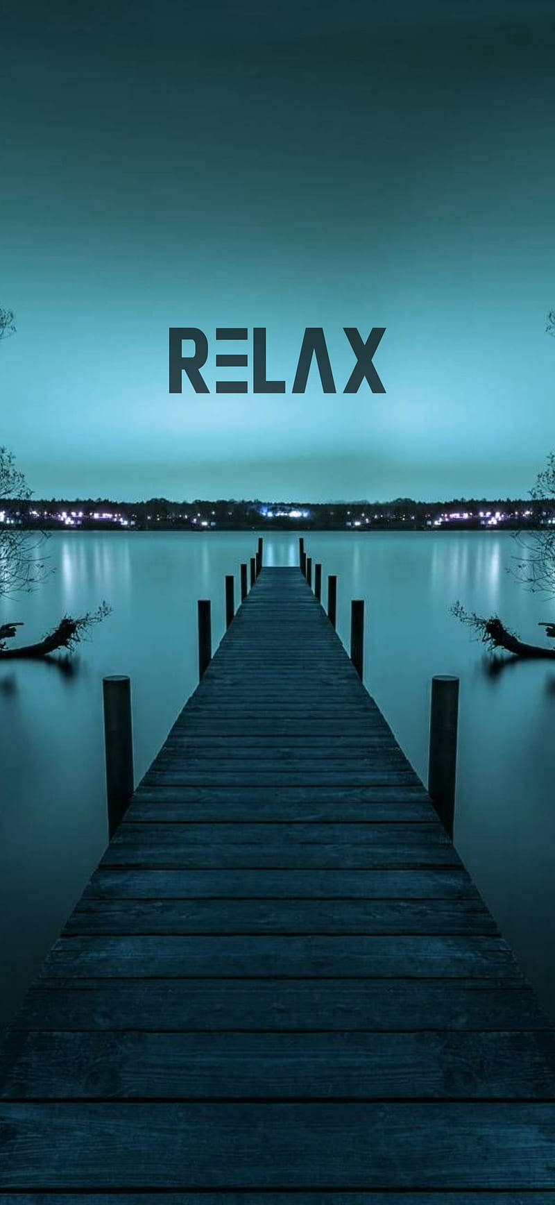 夜晚寧靜的木製碼頭，城市燈光倒映在水面上，上方有relax字樣。 — 勵志手機桌布 壁紙