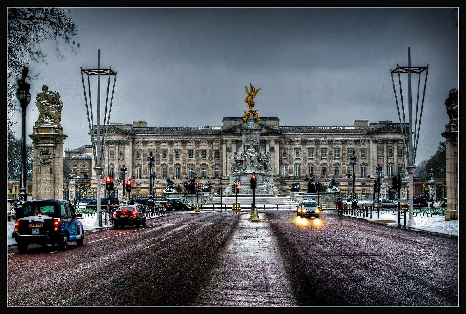 England 桌布 壁紙 — 一條濕漉漉的倫敦街道，在陰沉天空下通往白金漢宮，沿途有汽車和雕像。