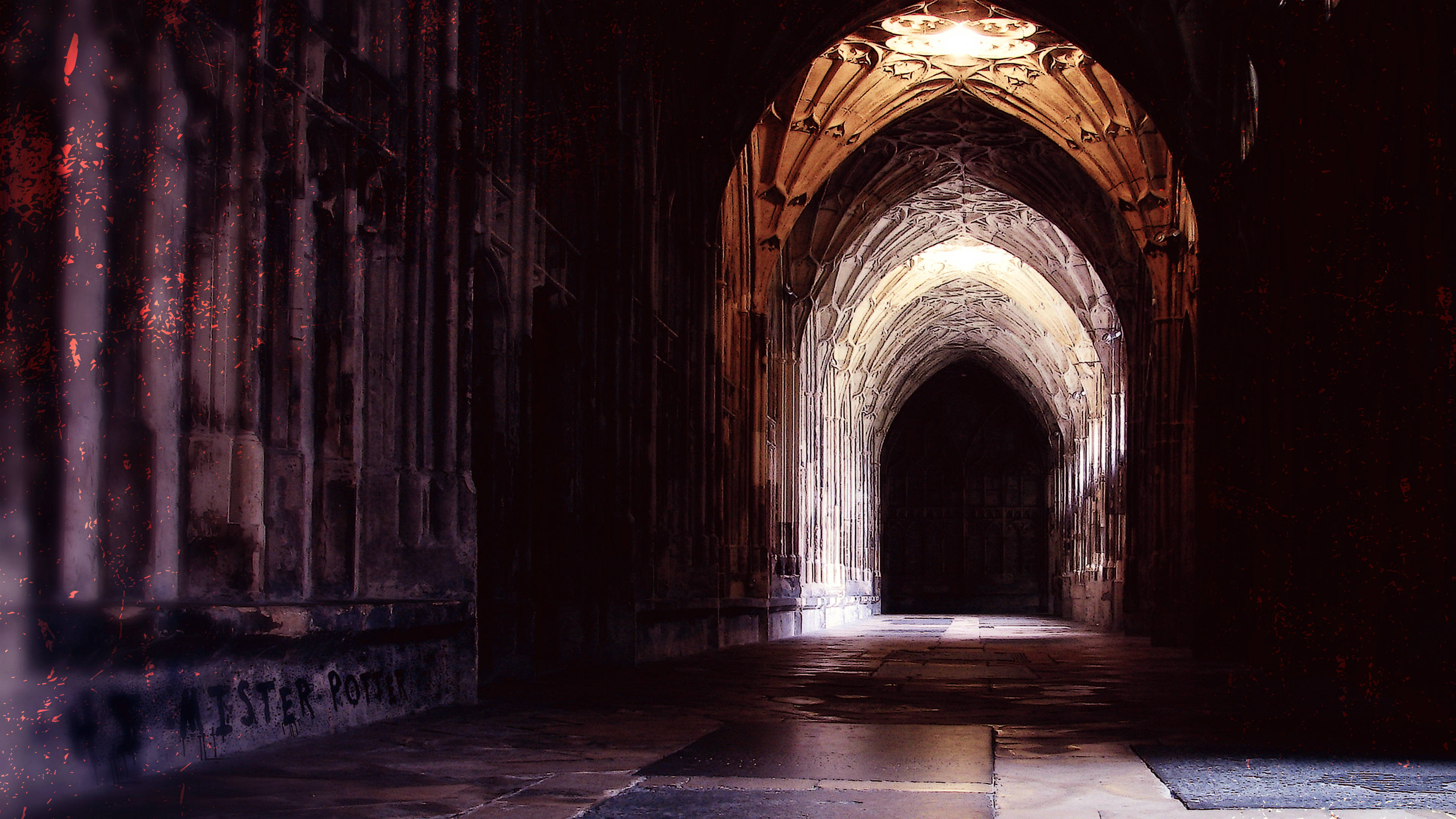 Hogwarts Aesthetic 桌布 壁紙 — 一條燈光昏暗的哥德式石頭走廊，拱形天花板和牆上的塗鴉通向黑暗。