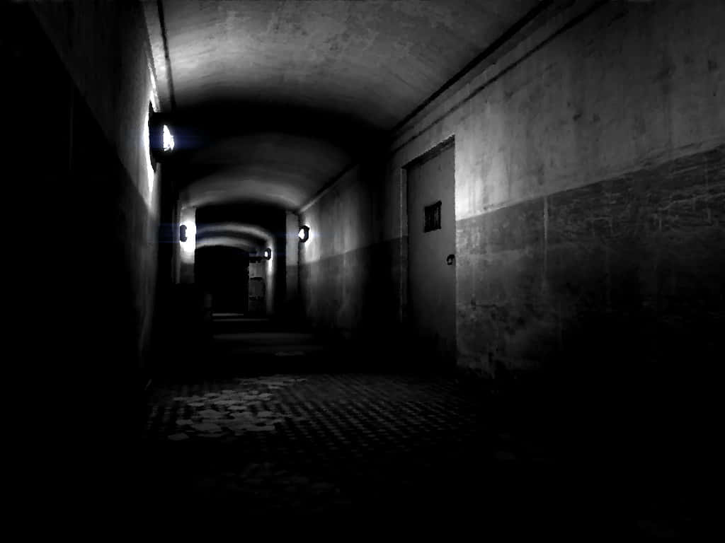 Dark Corner 桌布 壁紙 — 一條燈光昏暗的長混凝土隧道，閃爍的燈光在紋理牆壁和棋盤格地板上投射出詭異的陰影。