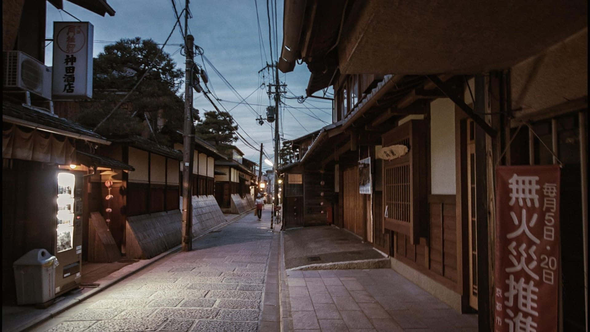 Road 桌布 壁紙 — 一條狹窄的傳統日本街道，黃昏時分，木造建築、燈籠，以及一個孤獨的身影在暮色天空下走遠。