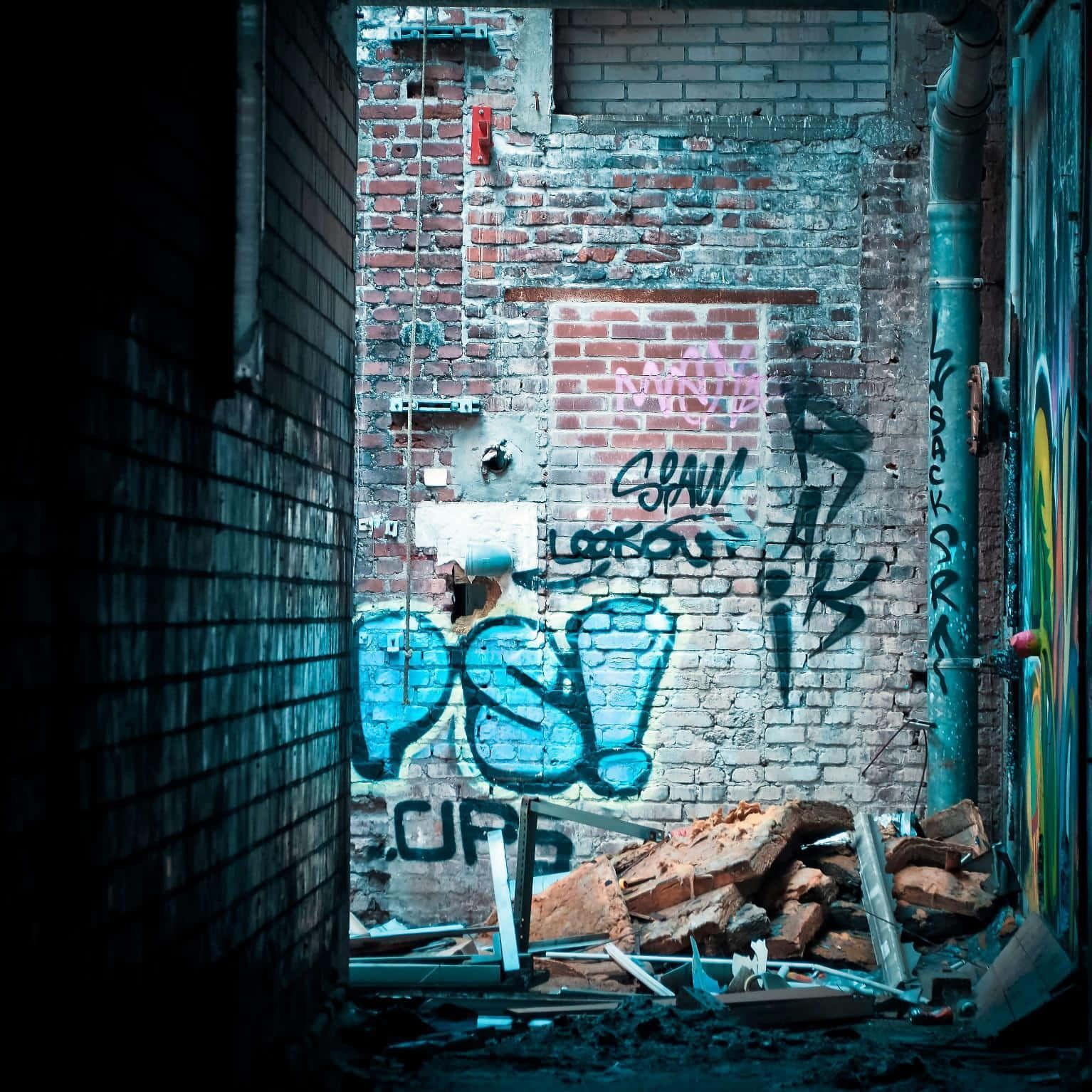 Ghetto Hood 桌布 壁紙 — 一條狹窄的小巷，兩旁是磚牆，牆上佈滿鮮豔的塗鴉和雜物，在冷藍色燈光下。