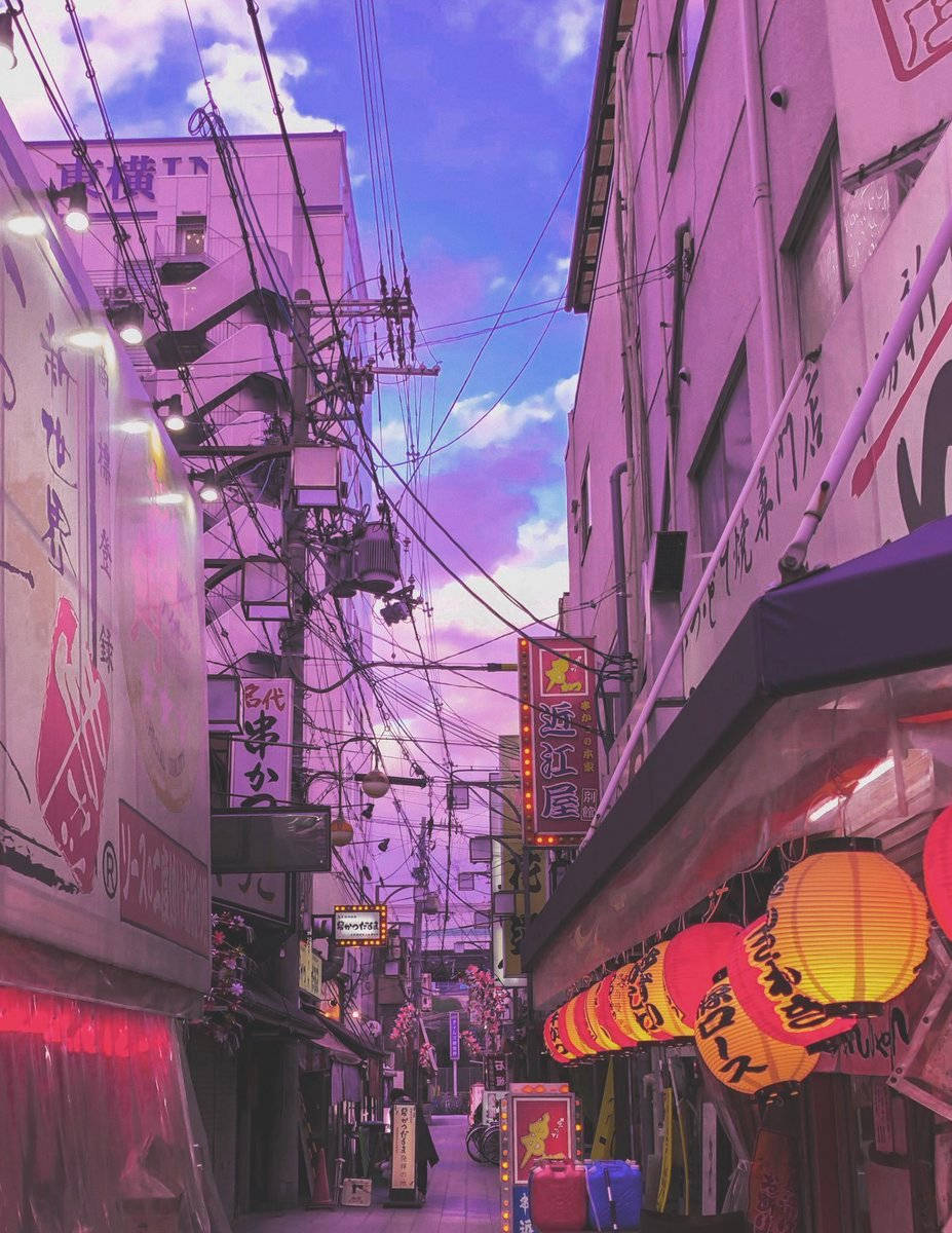 Japanese Aesthetic 桌布 壁紙 — 一條狹窄的日本小巷，沐浴在紫色暮色中，發光的燈籠和霓虹燈招牌映襯著夢幻般的天空。
