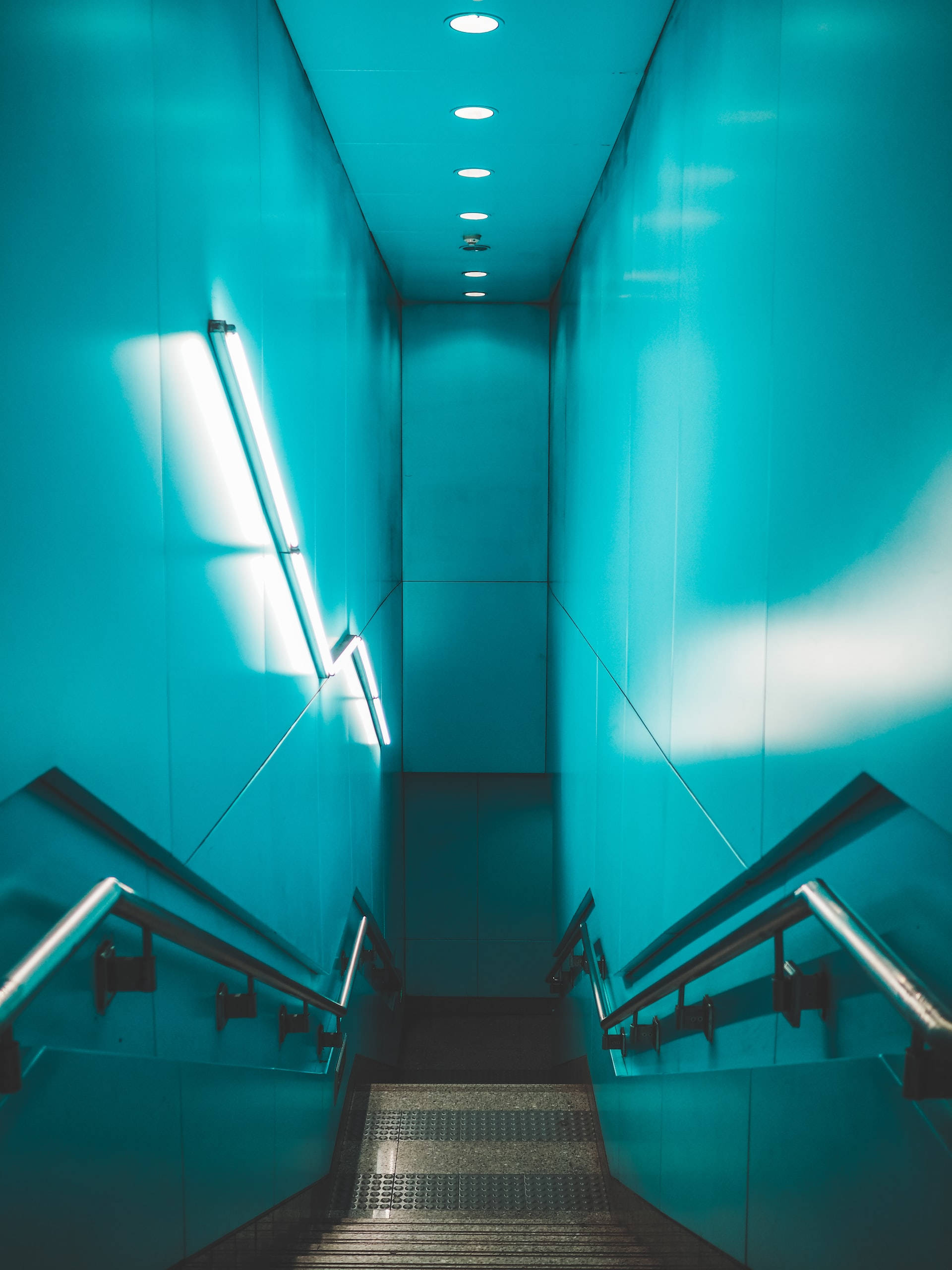 stairs 桌布 壁紙 — 一條狹窄的樓梯穿過由頭頂燈光和螢光燈條照亮的發光青綠色牆壁隧道向上延伸。