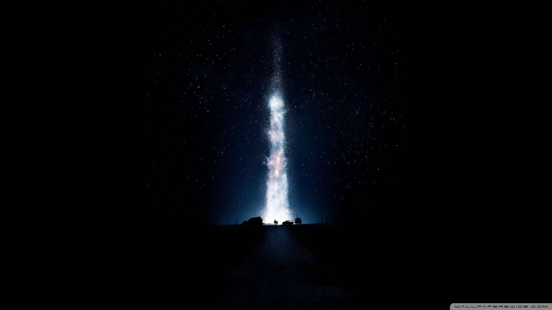 星際效應 桌布 壁紙 — 一條狹窄的道路通向一道發光的垂直星系，刺穿滿天星斗的夜空，其底部有剪影人物。