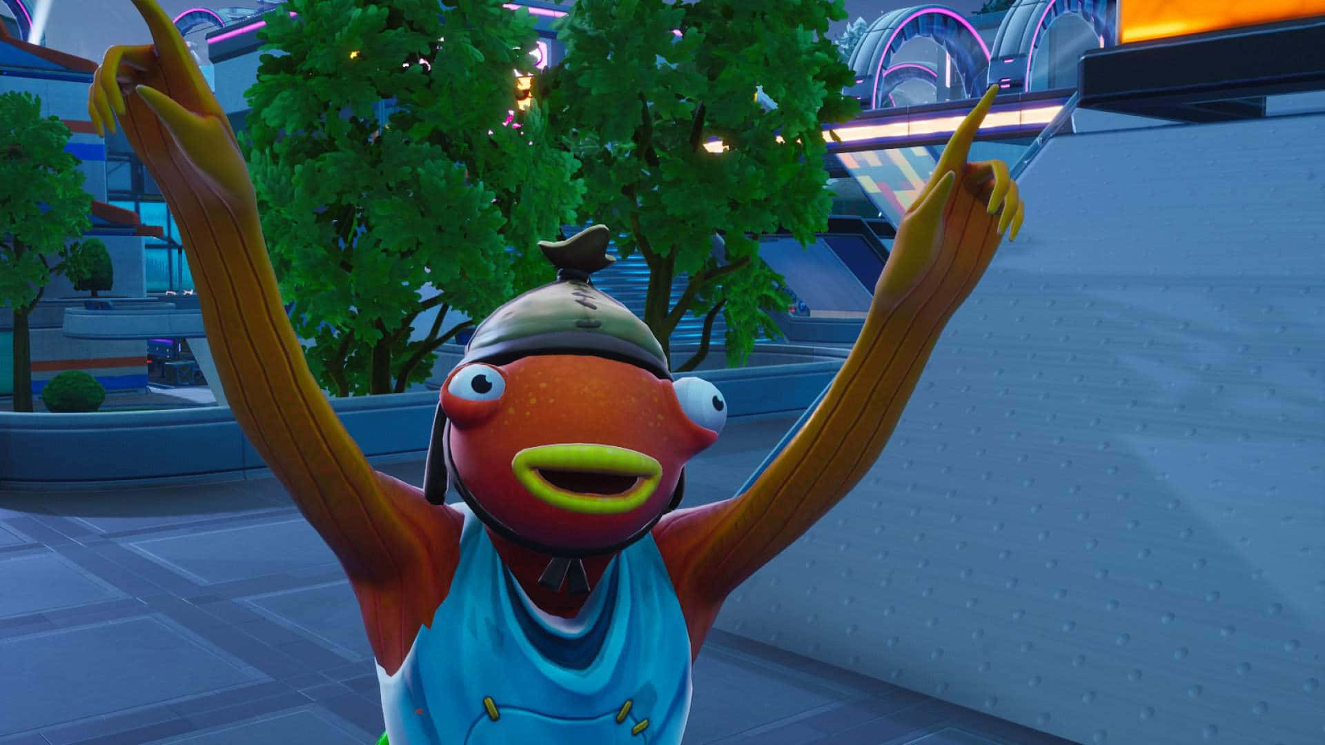 Fortnite Fishstick 桌布 壁紙 — 一條穿著藍色背心和帽子的卡通魚角色，在未來城市景觀中舉起雙臂慶祝。
