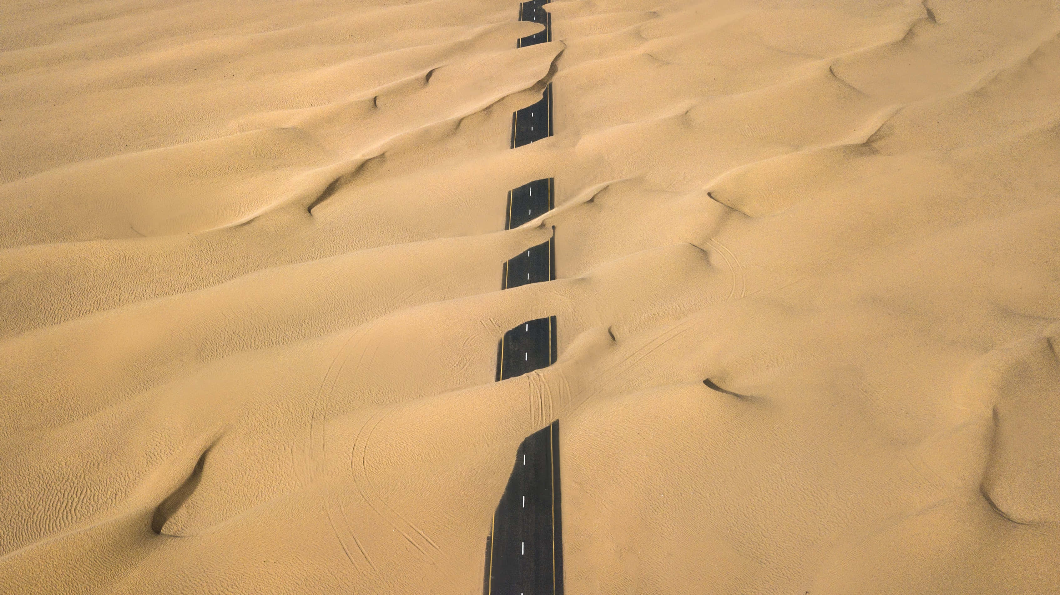 sand 桌布 壁紙 — 一條筆直的柏油公路在明亮的日光下穿過無盡的金色沙丘。