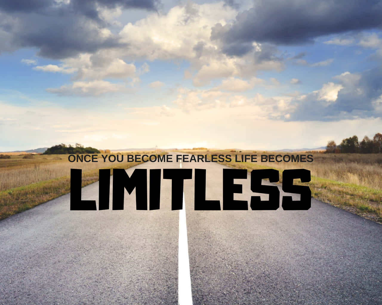 Inspirational Quotes 桌布 壁紙 — 一條筆直的瀝青路在戲劇性的天空下延伸至地平線，並以粗體文字宣告「ONCE YOU BECOME FEARLESS LIFE BECOMES LIMITLESS」。