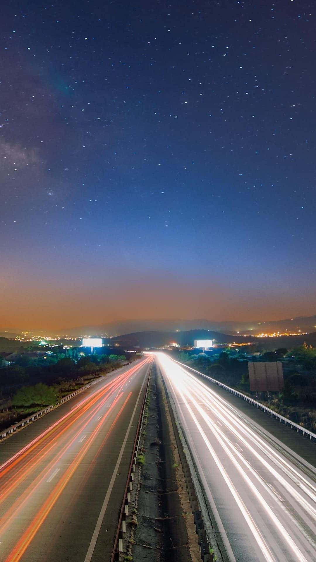 time lapse 桌布 壁紙 — 一條繁星點點的夜間高速公路，車燈光線在銀河天空下流動。