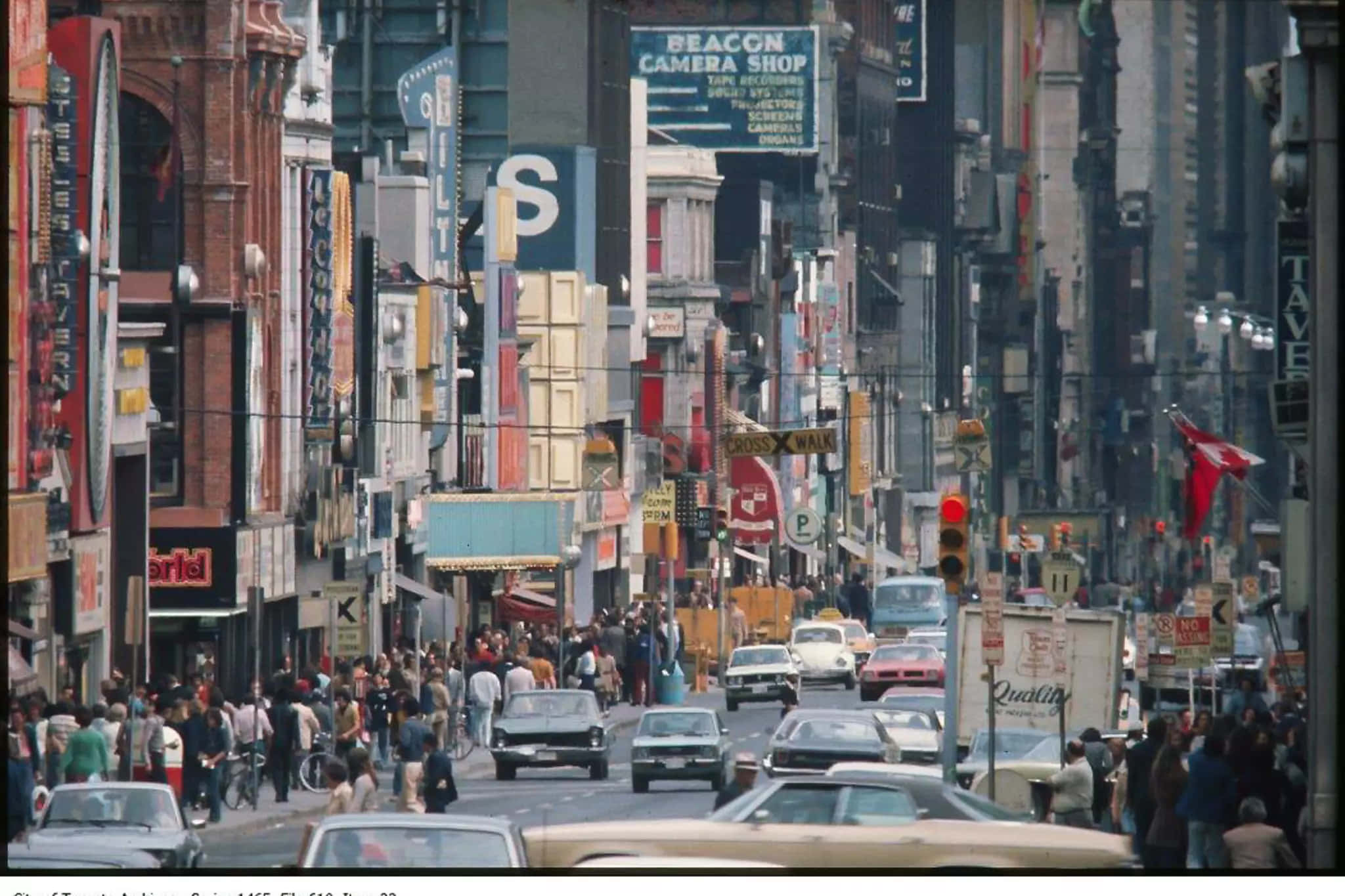 1980s 桌布 壁紙 — 一條繁華的1960年代城市街道，擠滿行人、老爺車和裝飾著色彩繽紛招牌和廣告的高聳建築物。