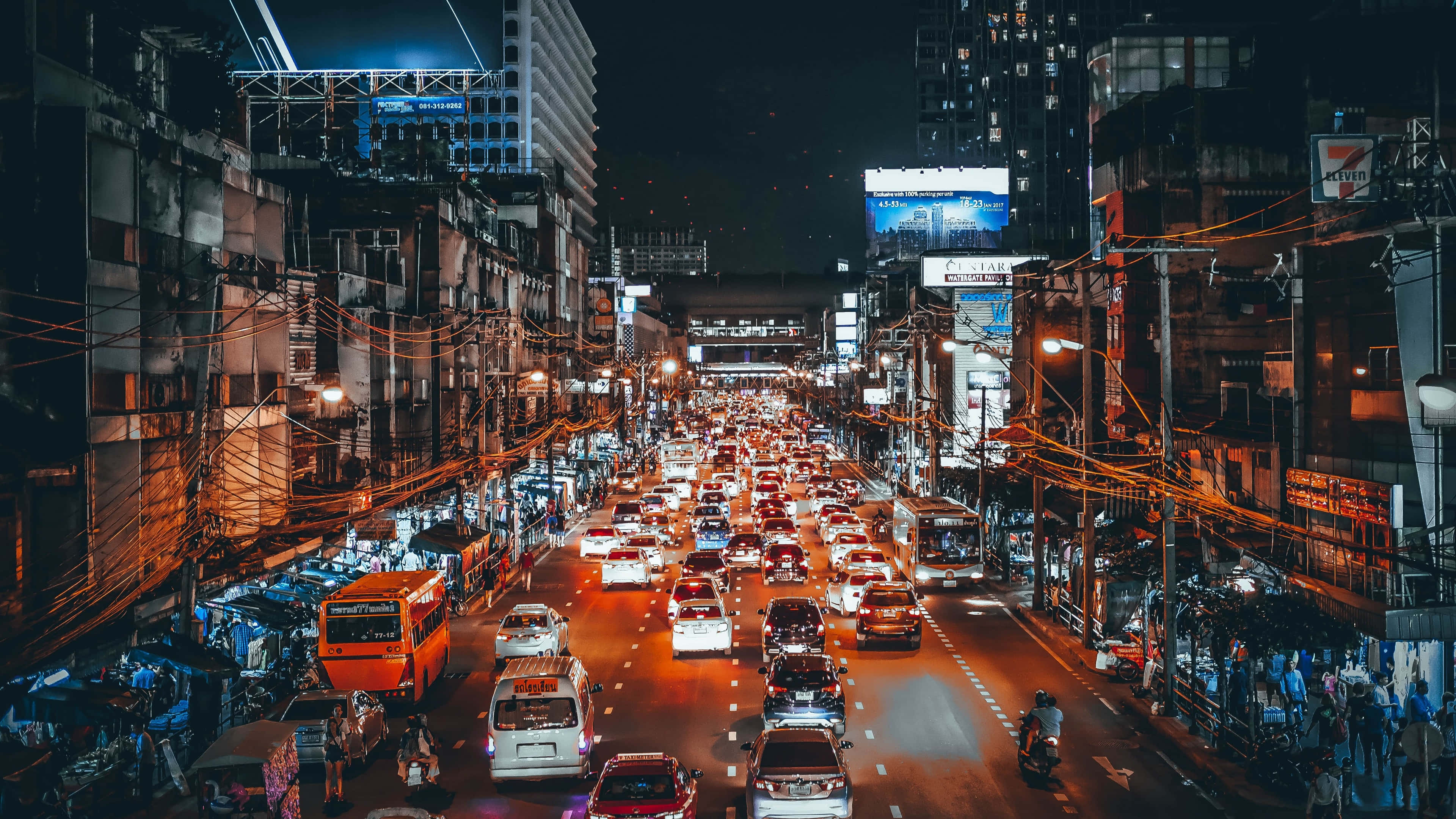 Night Street 桌布 壁紙 — 一條繁華的霓虹燈城市街道，夜晚充滿密集的交通和高聳的建築物。