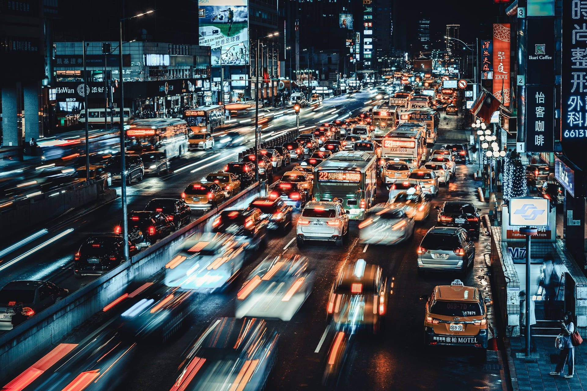 夜晚的城市街道，充滿行駛中的汽車和發光的霓虹招牌。