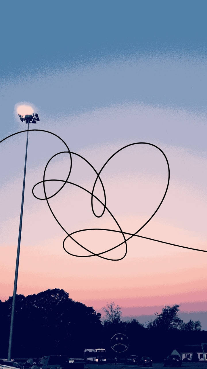 Bts Aesthetic 桌布 壁紙 — 一條纏繞的黑色電線在暮色天空下形成心形，上方有體育場燈光閃耀。
