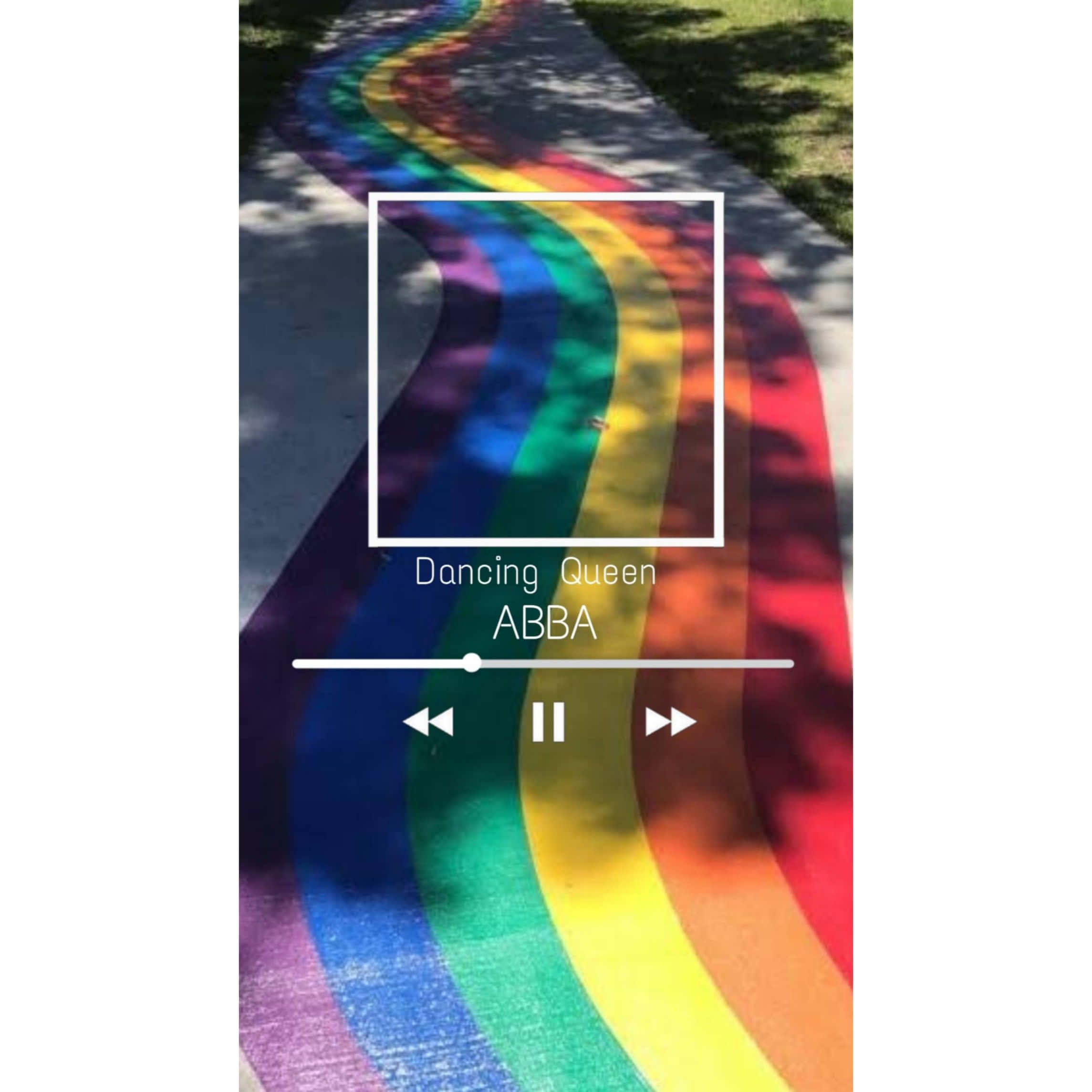 Pride Aesthetic 桌布 壁紙 — 一條色彩繽紛的彩虹小徑蜿蜒穿過斑駁的陽光，並帶有ABBA的Dancing Queen音樂播放器疊加層。
