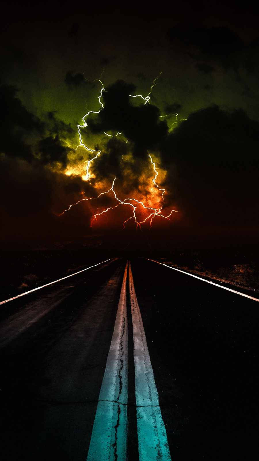 閃電 桌布 壁紙 — 一條荒涼的道路延伸向暴風雨的天空，天空中有鮮豔的橙色和綠色閃電，構成戲劇性的夜景。