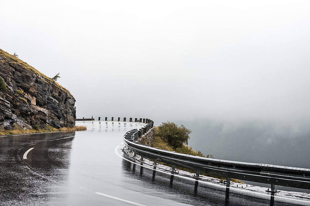 Raining 桌布 壁紙 — 一條蜿蜒潮濕的山路蜿蜒穿過迷霧，一側是岩石峭壁，下方是霧氣瀰漫的深淵。