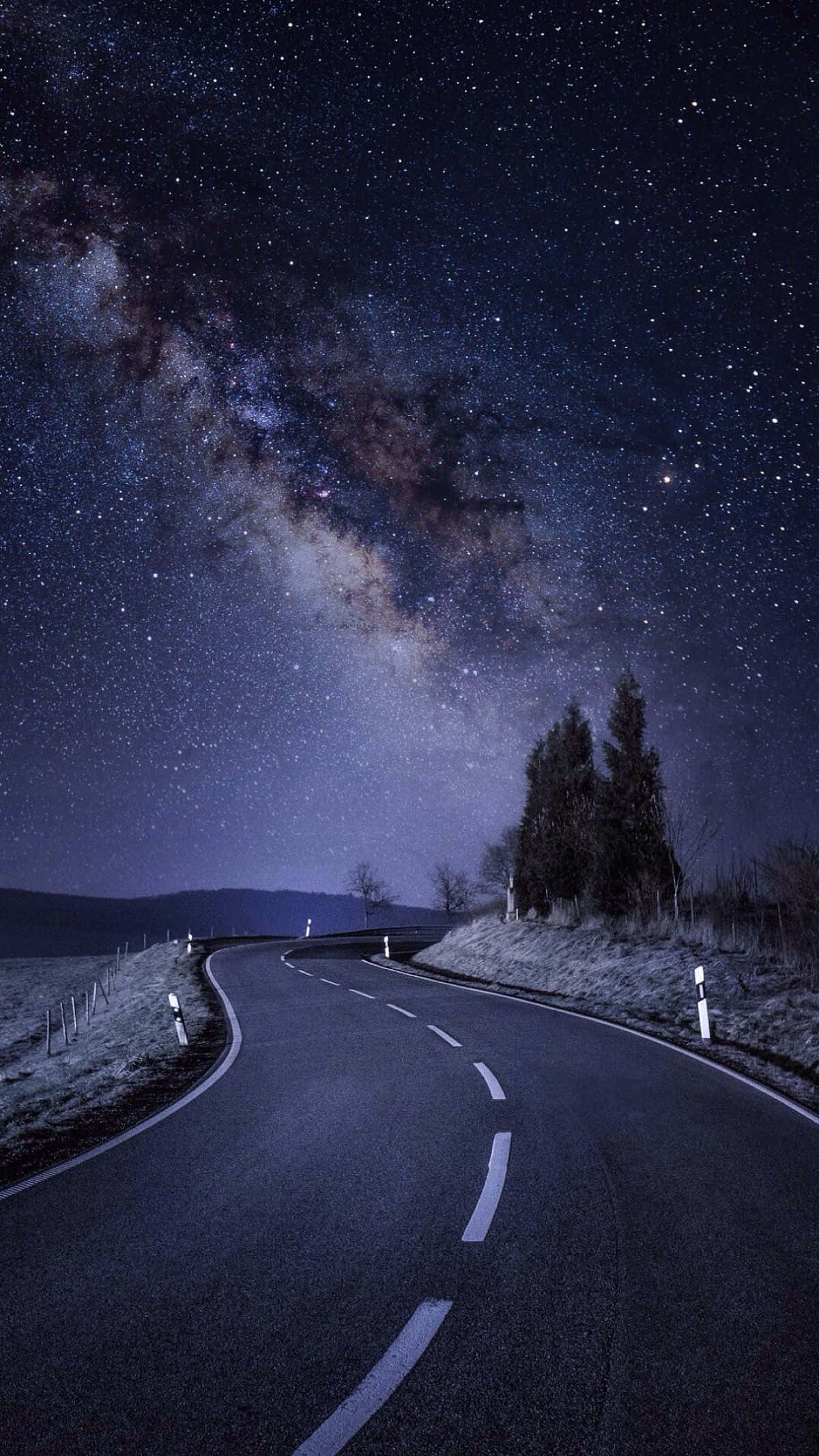 桌布 壁紙 — 一條蜿蜒的道路在令人驚嘆的星空下蜿蜒而行，銀河在頭頂閃耀。