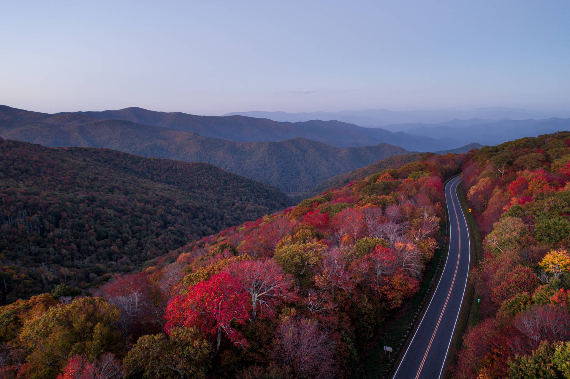 暮色中蜿蜒的道路穿過色彩繽紛的秋山 — 4K秋日壁紙 壁紙