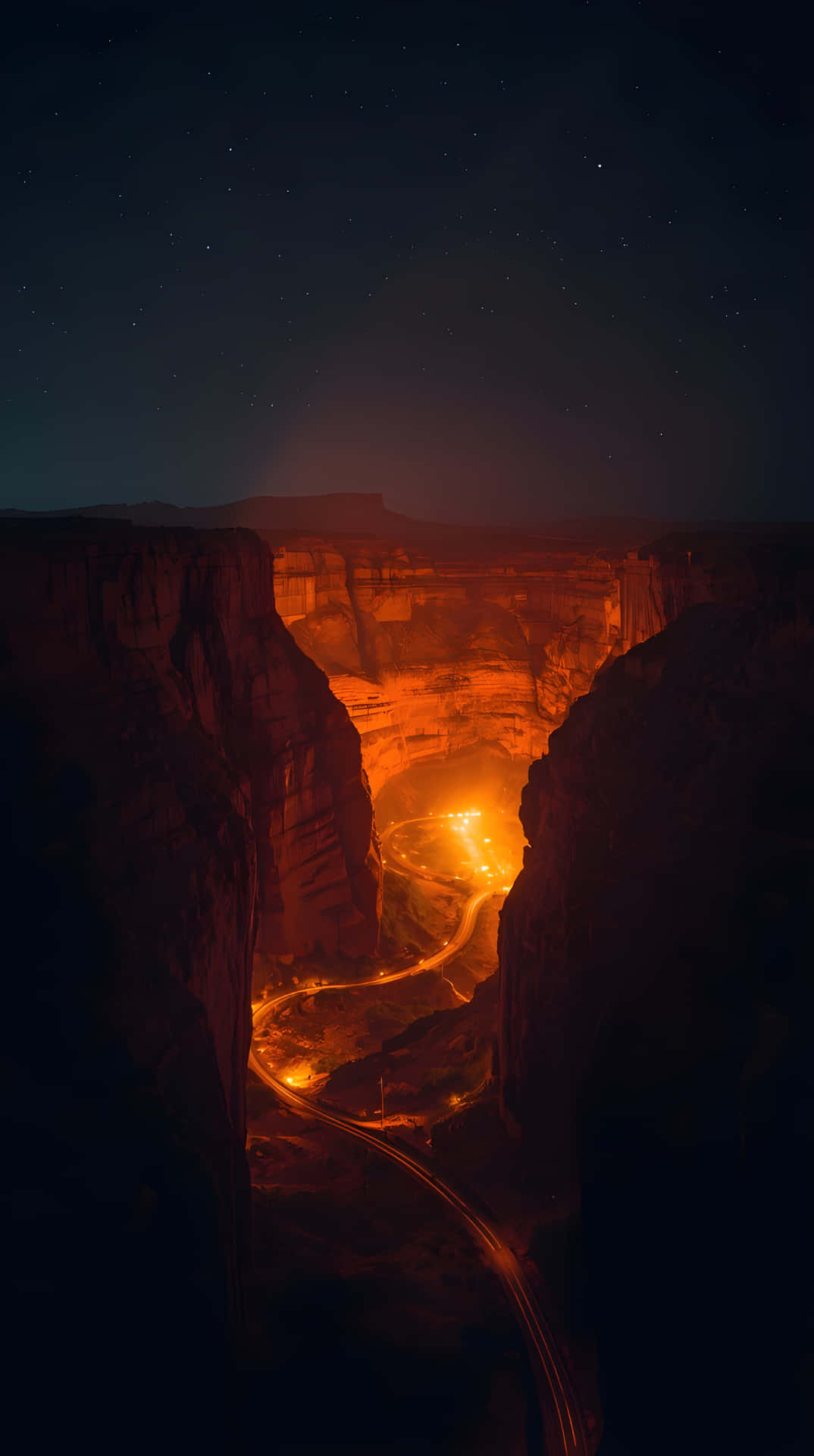 Epic Night Landscape Wallpaper 壁紙 — 一條蜿蜒的道路被溫暖的橙色燈光照亮，在星空下蜿蜒穿過深邃的峽谷。