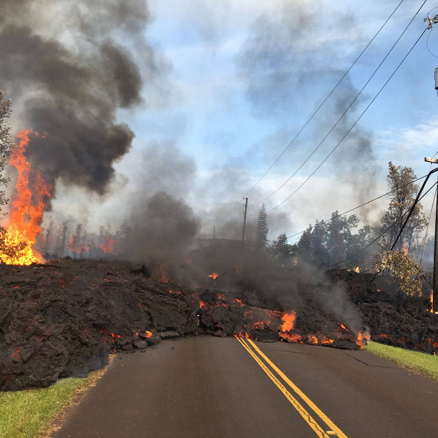 Kilauea Volcano 桌布 壁紙 — 一條被流動熔岩和滾滾濃煙堵塞的道路，天空局部多雲。