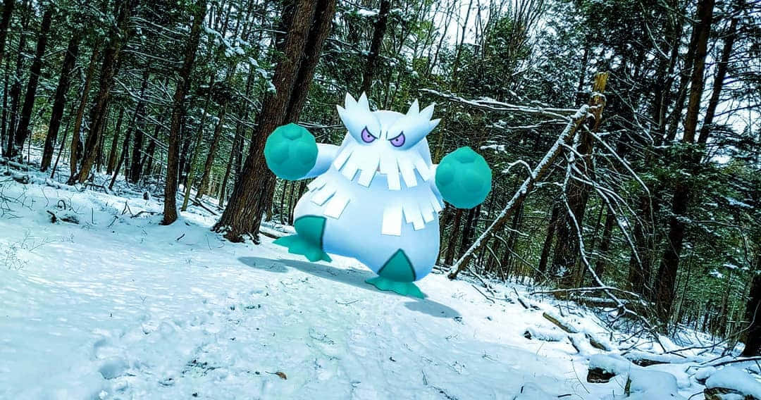 冬天 桌布 壁紙 — 一條被雪覆蓋的森林小徑上，有一隻大型藍白相間、眼睛發光的寶可夢站在積雪的樹木之間。