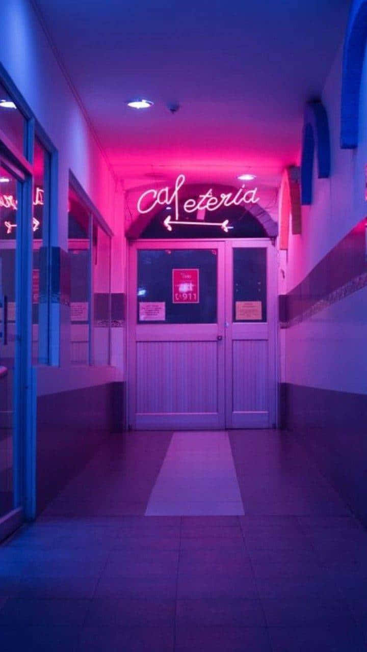 Lo Fi Aesthetic 桌布 壁紙 — 一條走廊沐浴在充滿活力的粉紅色和藍色霓虹燈光中，通向雙門上方發光的「Cafeteria」標誌。