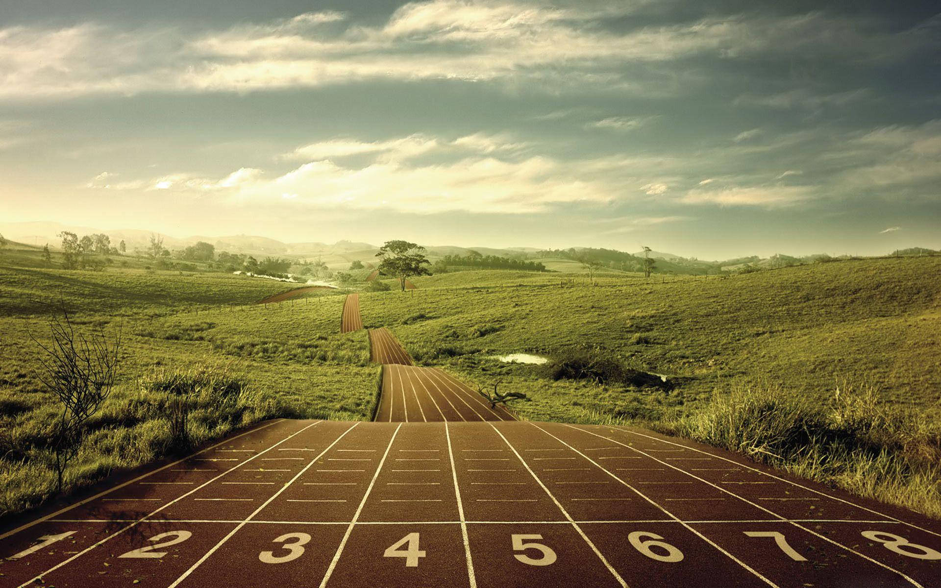 Athletic 桌布 壁紙 — 一條跑道穿過起伏的綠色山丘，在黃金時段戲劇性的多雲天空下延伸。