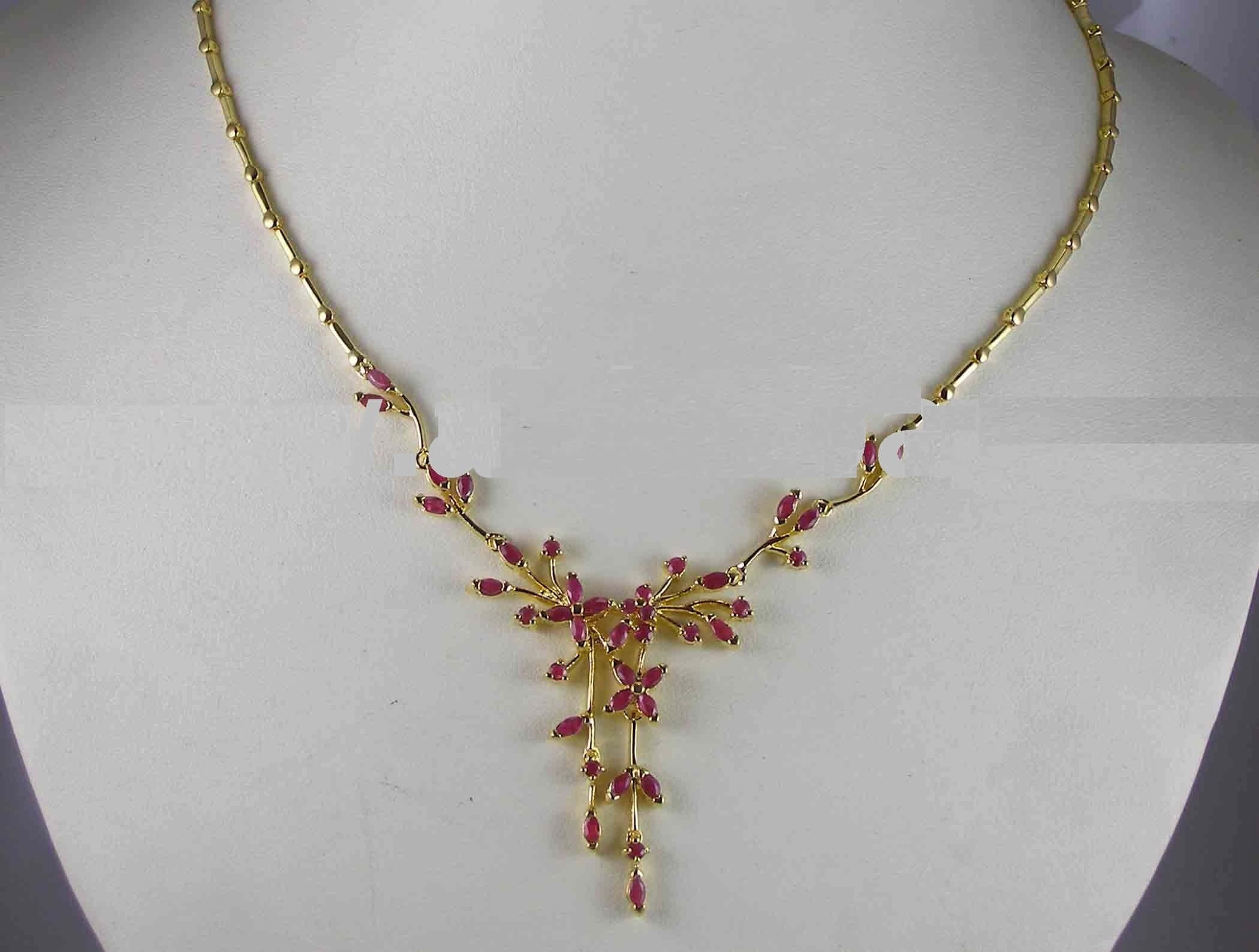 Jewelry Design 桌布 壁紙 — 一條金色項鍊，飾有粉紅色寶石，形狀像盛開的樹枝，展示在白色模特兒半身像上。