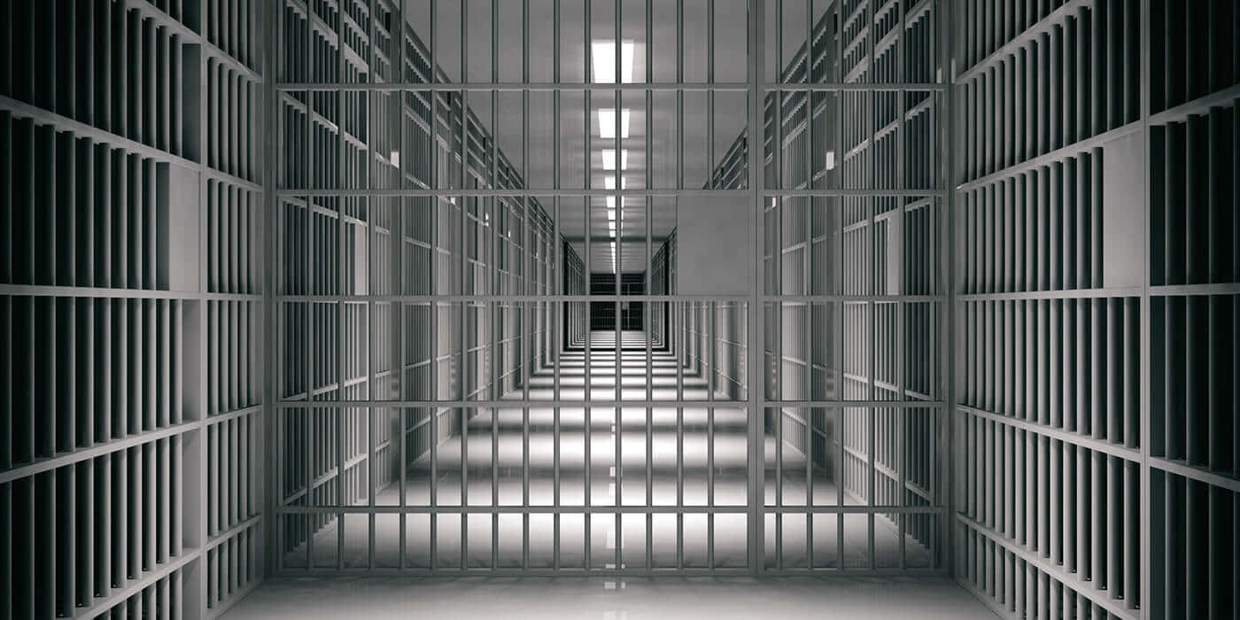 Prison 桌布 壁紙 — 一條長而無菌的監獄走廊，兩旁是金屬欄杆的牢房，上方是螢光燈。